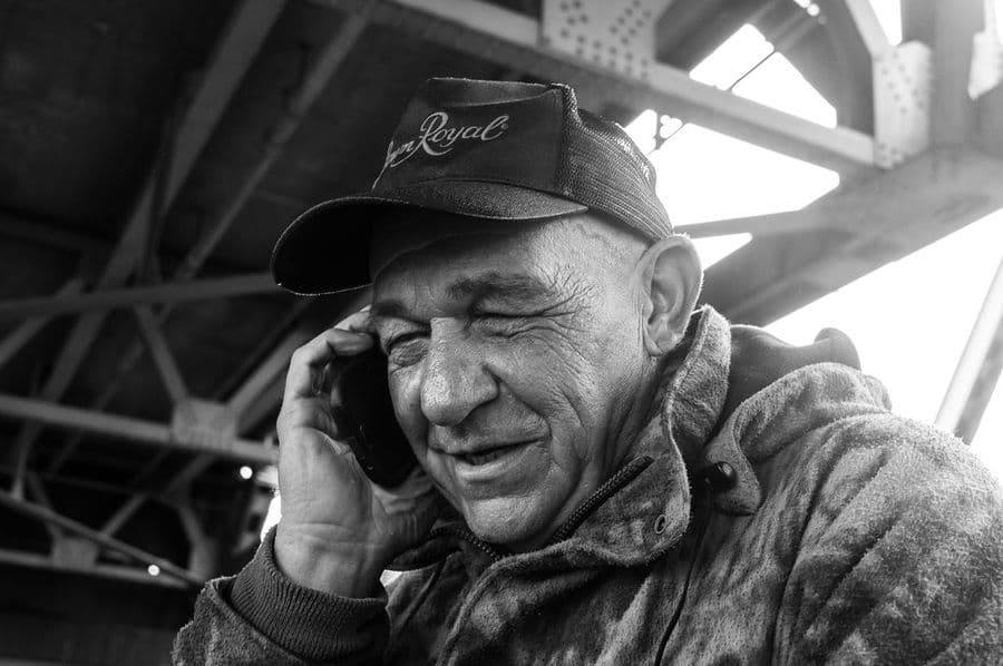 An elderly man laughing during a phone call